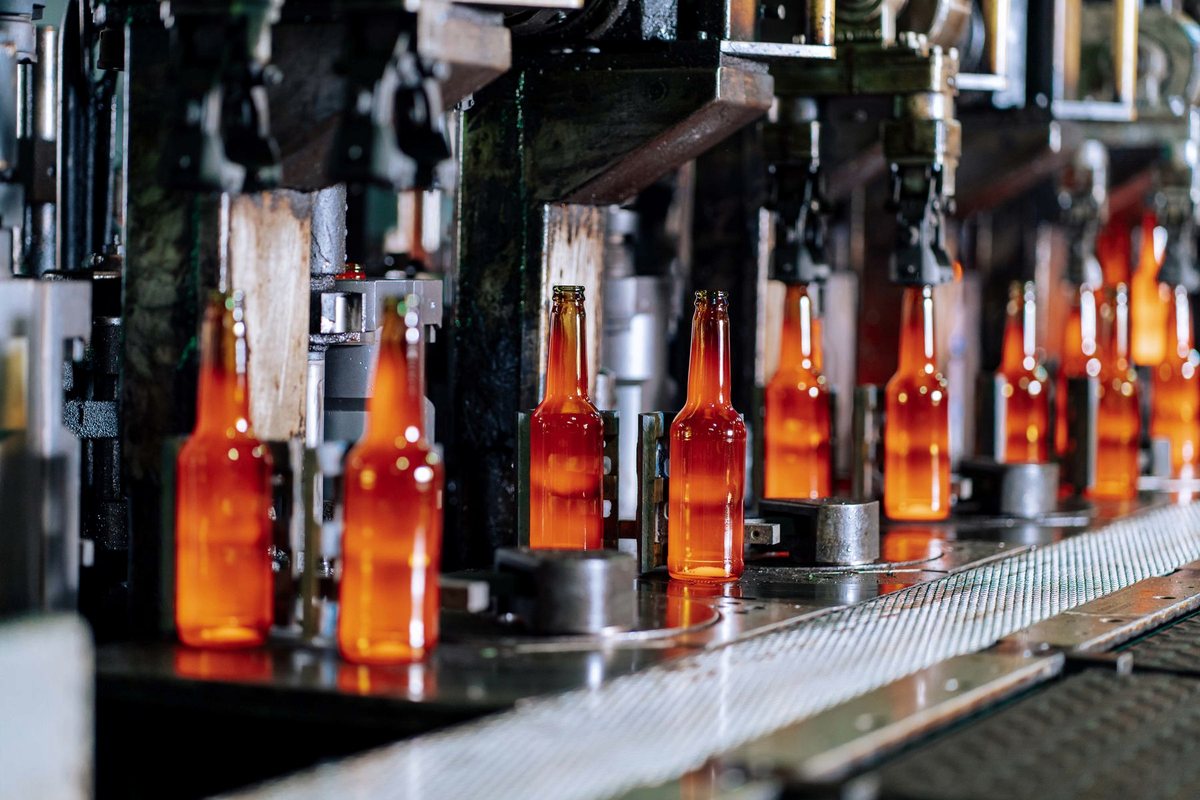 Hot glass bottles moving through an automated production line